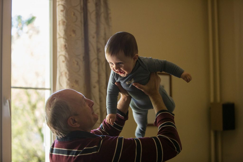 Grandfather playing with grandson in family home